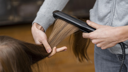 Woman straightening another woman's hair